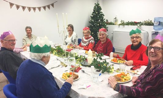 The local group seated about to eat Christmas lunch