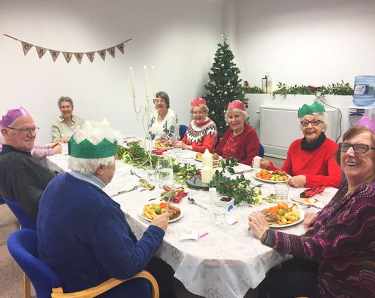 The local group seated about to eat Christmas lunch