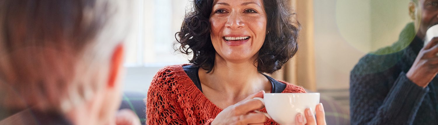 woman talking to a man smiling and holding a mug
