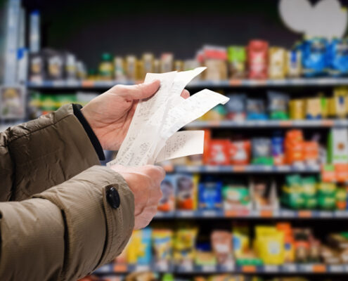 mans hands holding a long receipt in a grocery shop
