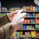 mans hands holding a long receipt in a grocery shop
