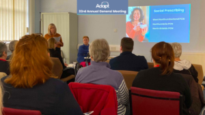 Photo of people sat in the room, with a presentation on the wall.